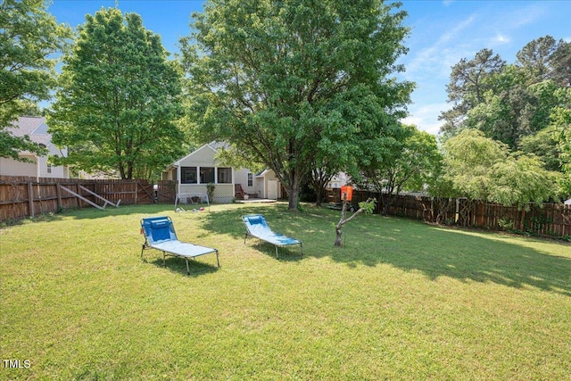 view of yard with a storage shed, an outbuilding, and a fenced backyard