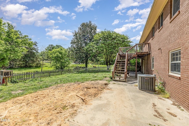 view of yard featuring a wooden deck, a fenced backyard, stairs, a patio area, and central air condition unit