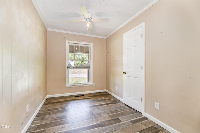 empty room with baseboards, ceiling fan, ornamental molding, and wood finished floors