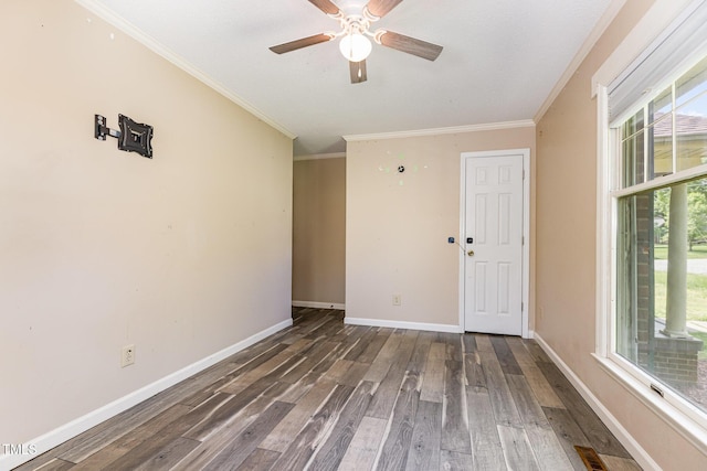 spare room with crown molding, ceiling fan, baseboards, and wood finished floors