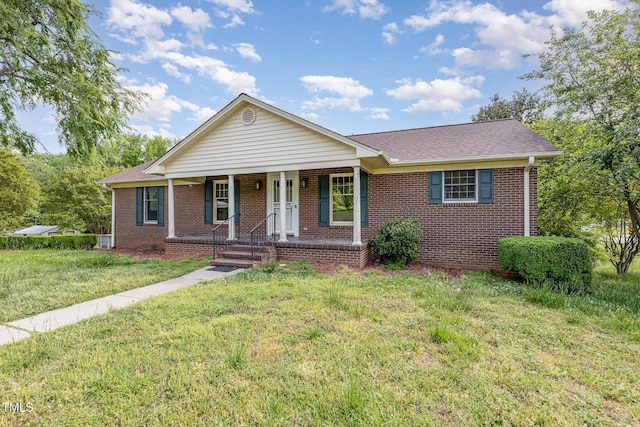 view of front of house with covered porch, brick siding, a shingled roof, and a front lawn