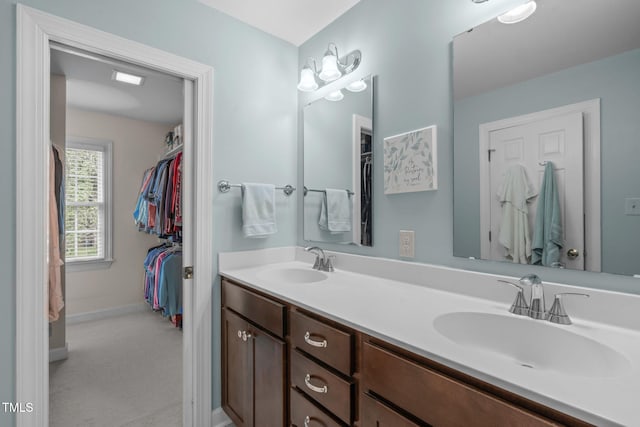 bathroom with double vanity and baseboards