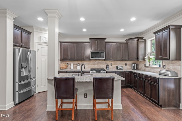 3304 Rockland Ridge Dr, Cary, NC 27519 - kitchen with appliances with stainless steel finishes, a sink, dark brown cabinets, a kitchen island with sink, and recessed lighting