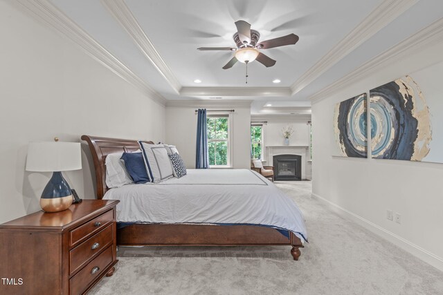3304 Rockland Ridge Dr, Cary, NC 27519 - bedroom featuring light carpet, a tray ceiling, baseboards, crown molding, and a glass covered fireplace