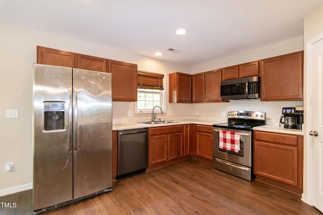 kitchen featuring visible vents, a sink, light countertops, stainless steel appliances, and dark wood-type flooring