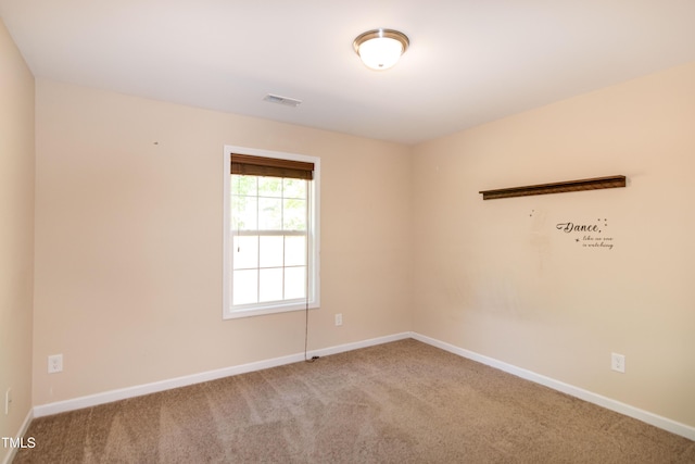 carpeted spare room featuring baseboards and visible vents