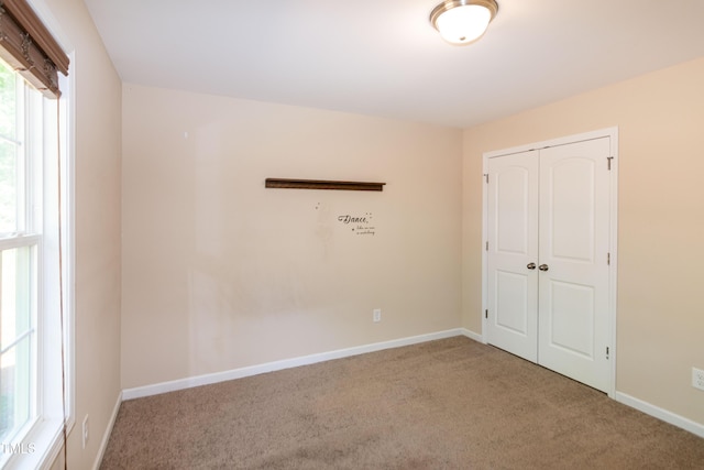 unfurnished room featuring baseboards and carpet