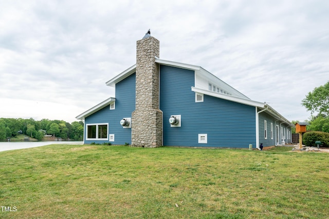 view of side of home with a yard and a chimney