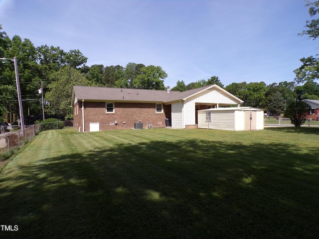 4908 Mandel Rd, Durham, NC 27712 - back of house featuring a shed, an outbuilding, brick siding, and central AC