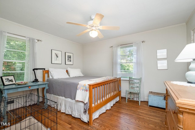 bedroom with crown molding, ceiling fan, baseboards, and wood finished floors