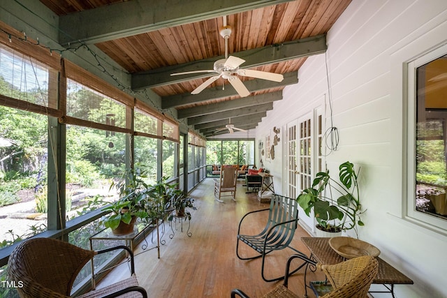 sunroom featuring a ceiling fan and beamed ceiling