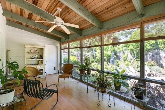 sunroom featuring ceiling fan, a wealth of natural light, wood ceiling, and beam ceiling