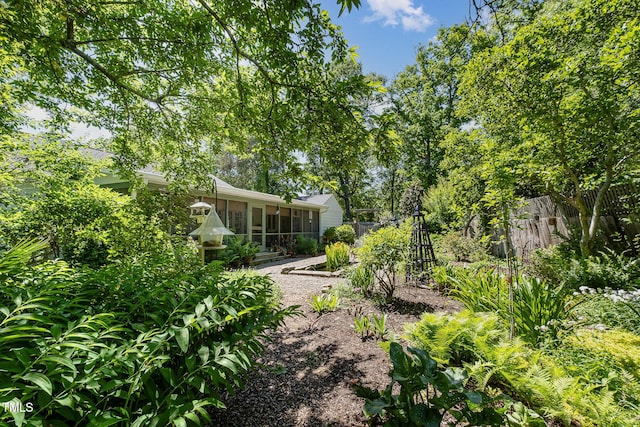 view of yard with a sunroom and fence