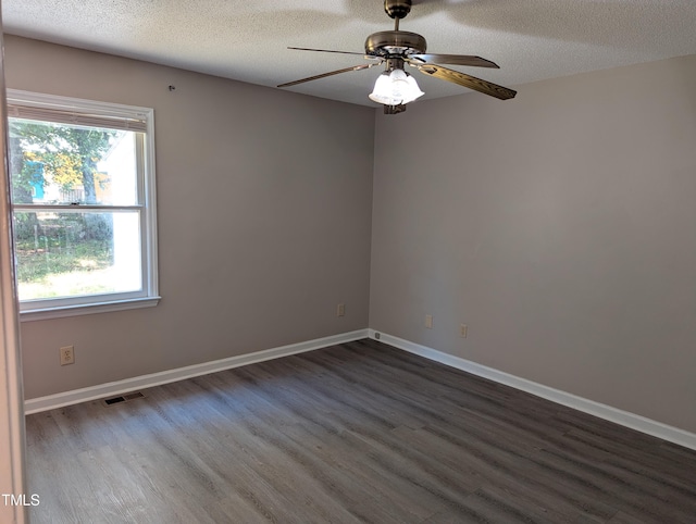 unfurnished room featuring visible vents, dark wood-style flooring, baseboards, a textured ceiling, and a ceiling fan