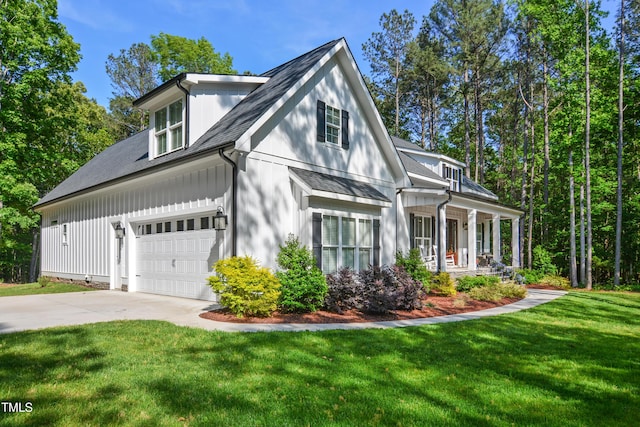 view of front of home featuring roof with shingles, covered porch, concrete driveway, and a front lawn