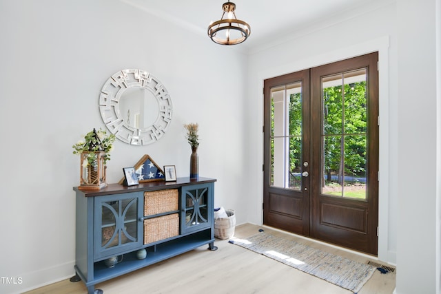 foyer entrance featuring a chandelier, french doors, wood finished floors, and visible vents