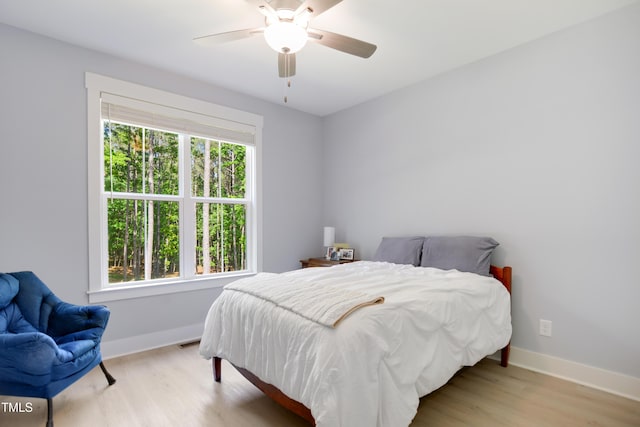 bedroom with baseboards, ceiling fan, and wood finished floors