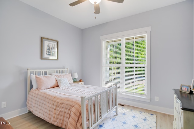 bedroom with light wood-style floors, baseboards, and multiple windows