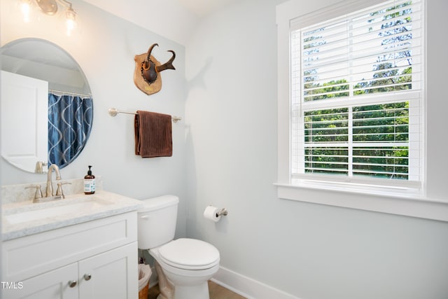 bathroom with vanity, baseboards, and toilet