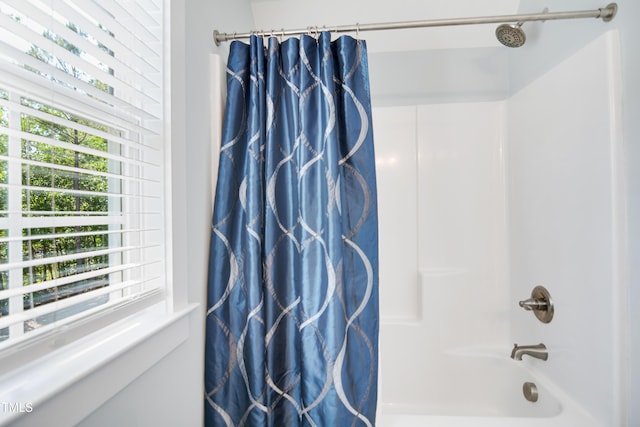 full bath with plenty of natural light and shower / bath combo with shower curtain