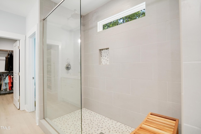 full bath featuring walk in shower, wood finished floors, and a walk in closet