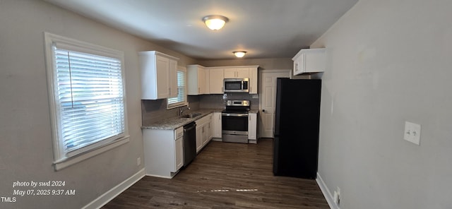 kitchen featuring stainless steel appliances, baseboards, a sink, white cabinets, and dark wood finished floors
