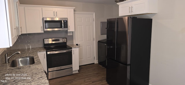 kitchen featuring stainless steel appliances, a sink, decorative backsplash, and white cabinetry