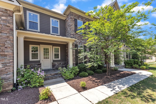 townhome / multi-family property featuring a porch and stone siding