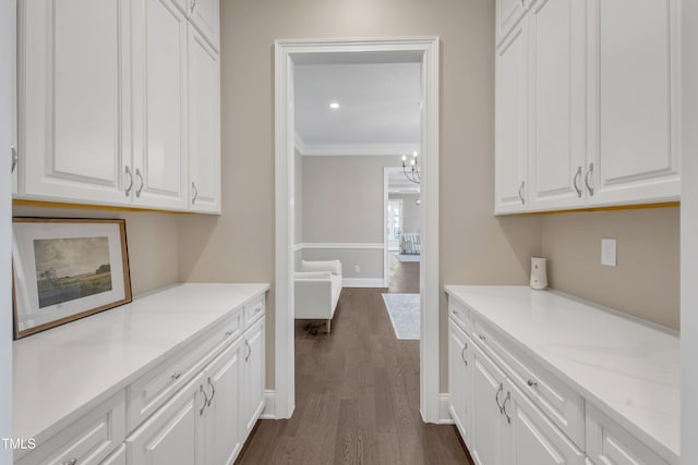interior space featuring crown molding, baseboards, an inviting chandelier, and dark wood-style flooring