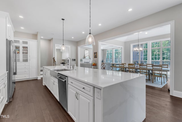 kitchen with white cabinets, appliances with stainless steel finishes, dark wood-style floors, and a sink