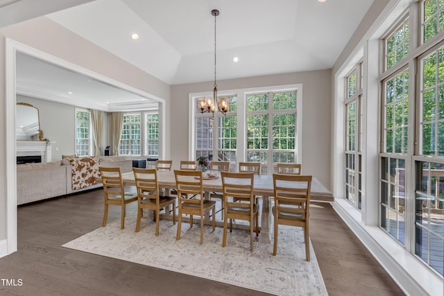 dining space featuring an inviting chandelier, recessed lighting, dark wood-style flooring, and a fireplace