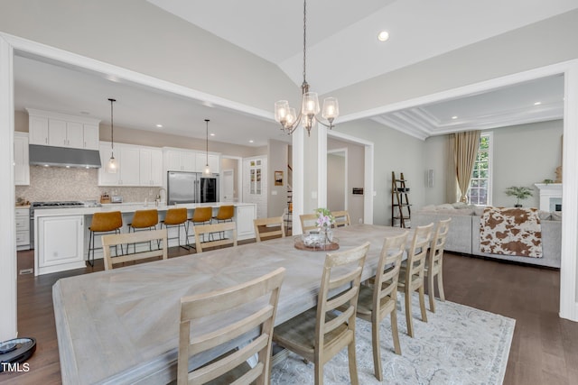 dining area with recessed lighting, a notable chandelier, dark wood-style floors, and vaulted ceiling