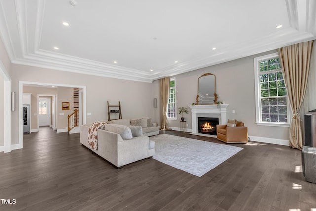 living area with crown molding, baseboards, a fireplace with flush hearth, and dark wood-style floors