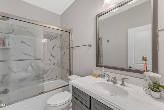 bathroom featuring toilet, bath / shower combo with glass door, and vanity