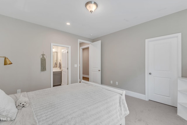 bedroom with baseboards, ensuite bathroom, light carpet, and recessed lighting