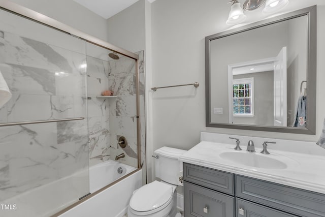 full bath with toilet, bath / shower combo with glass door, and vanity