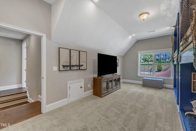 living room featuring baseboards, carpet flooring, and lofted ceiling