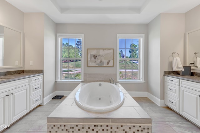 full bathroom with vanity, a tray ceiling, and a tub with jets