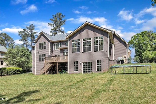 back of house with stairs, a trampoline, a lawn, and a deck