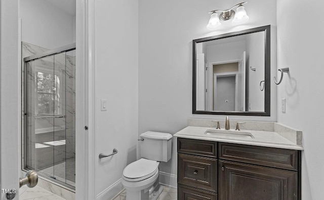 bathroom with a stall shower, vanity, baseboards, toilet, and marble finish floor