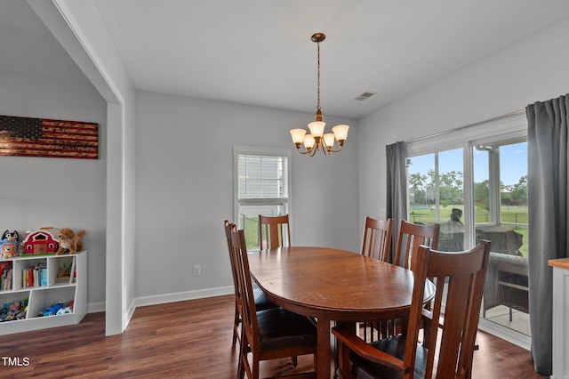 dining area featuring visible vents, dark wood finished floors, baseboards, and a notable chandelier