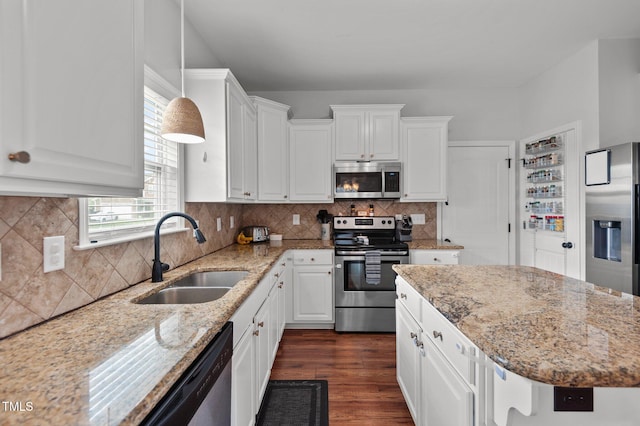 kitchen with a sink, appliances with stainless steel finishes, white cabinetry, and dark wood-type flooring