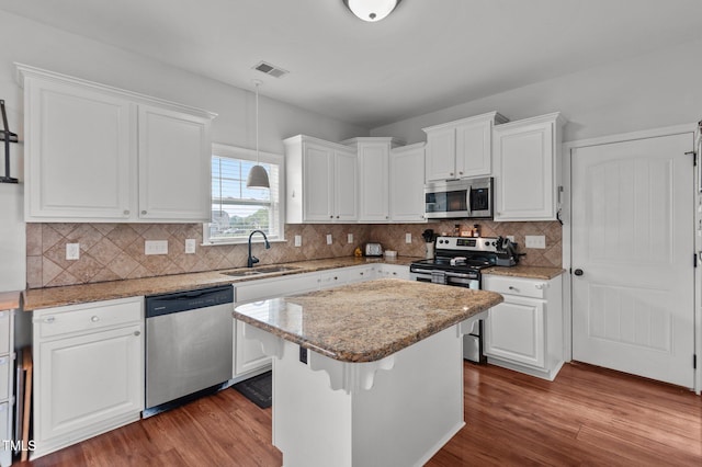 kitchen featuring visible vents, a sink, appliances with stainless steel finishes, and wood finished floors