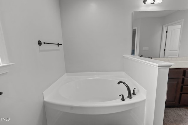 bathroom with vanity and a garden tub