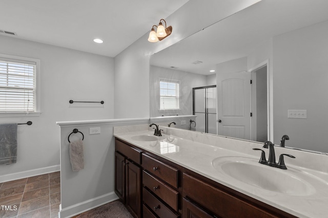 bathroom featuring visible vents, a sink, baseboards, and a stall shower
