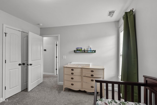 bedroom featuring light colored carpet, baseboards, visible vents, and a closet