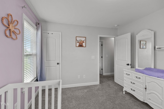 bedroom featuring dark colored carpet and baseboards