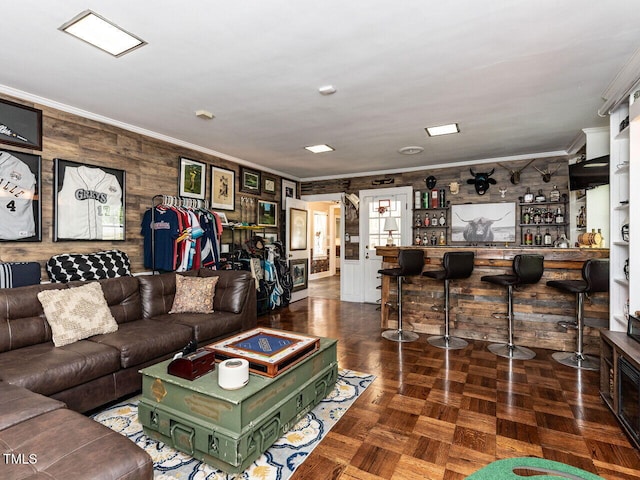 living room featuring ornamental molding, wooden walls, and indoor bar