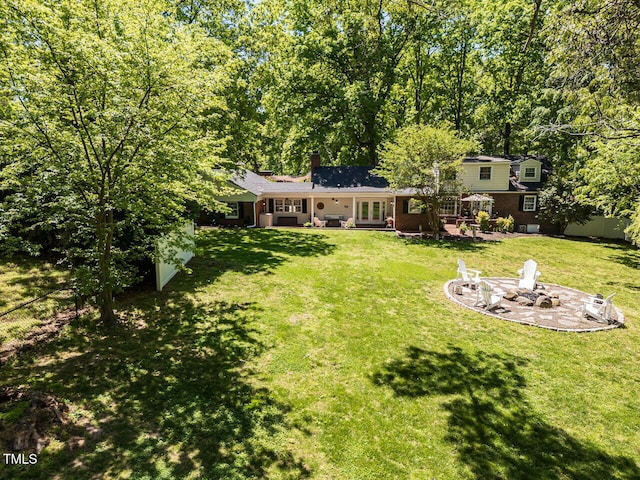 view of yard featuring french doors, a fire pit, and a patio area