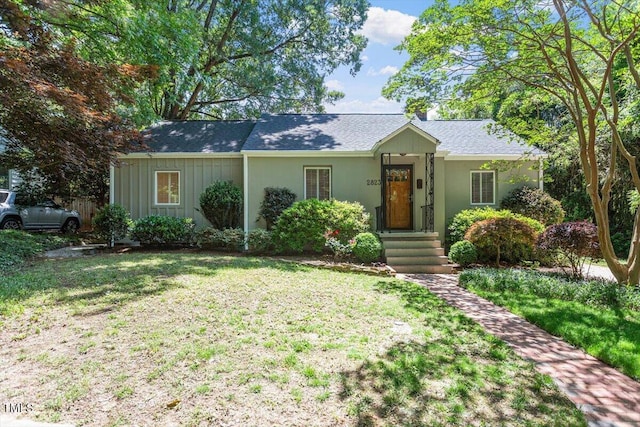 ranch-style house with a front yard and board and batten siding